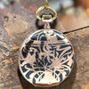 Decorative pocket watch with floral patterns on a wooden surface